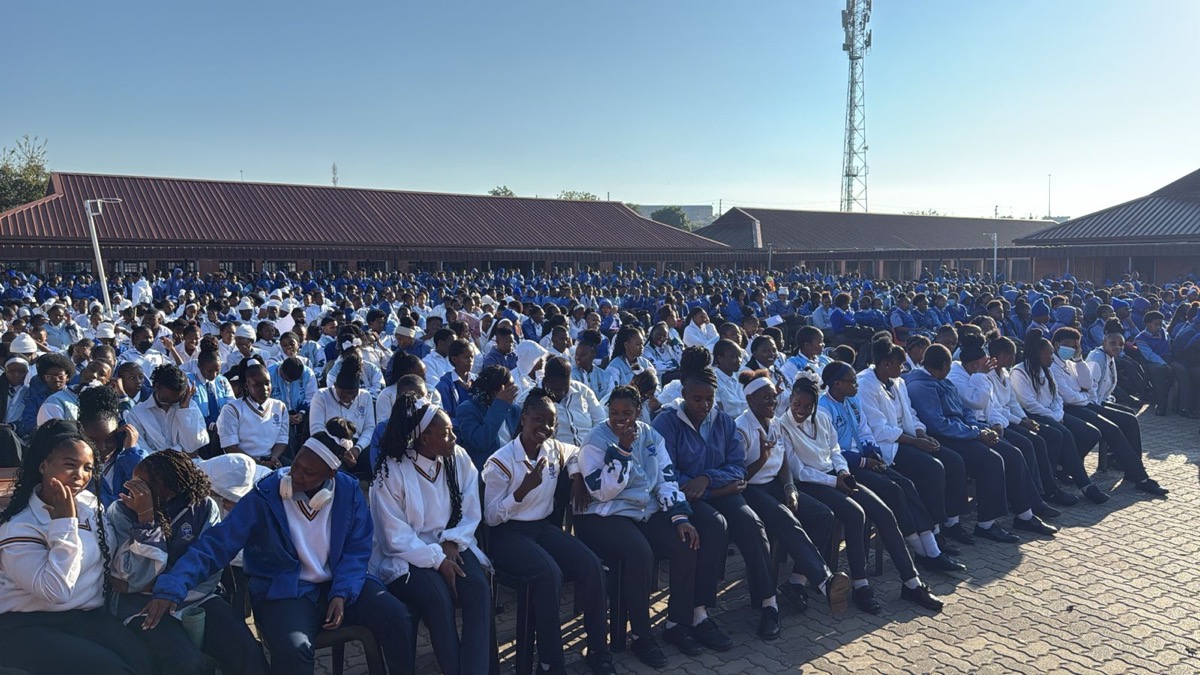 A large group of learners in school uniform seated outdoors for a Career Guidance assembly