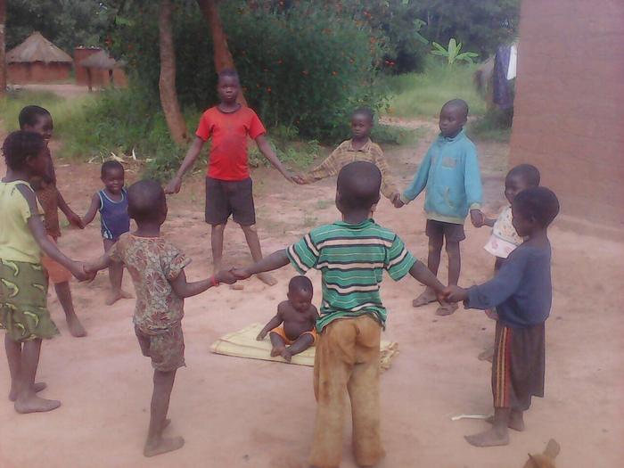 Children holding hands in a circle during an outdoor game