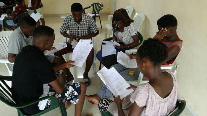 A junior youth group reading together indoors